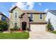 Charming two-story home with a stone archway, complemented by a well-manicured lawn and mature landscaping at 6012 Drave Ln, Fort Mill, SC 29715