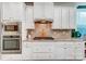 Modern kitchen featuring built-in stainless steel oven and microwave, gas cooktop, and white cabinetry at 6012 Drave Ln, Fort Mill, SC 29715