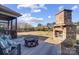 Spacious outdoor patio featuring a brick fireplace, seating, and backyard views at 6012 Drave Ln, Fort Mill, SC 29715