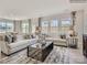 Open living room with large windows, comfortable sofas, and a coffee table at 1983 Copper Path Dr, Fort Mill, SC 29715
