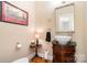 Charming powder room boasts wood floors and pedestal sink with a decorative framed mirror at 21315 Blakely Shores Dr, Cornelius, NC 28031