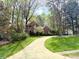 Traditional brick home featuring manicured landscaping and a circular driveway, nestled amongst mature trees at 21315 Blakely Shores Dr, Cornelius, NC 28031