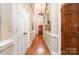 Inviting hallway features hardwood floors, wainscoting, and elegant lighting, leading to various rooms at 21315 Blakely Shores Dr, Cornelius, NC 28031