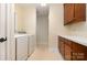 Well-lit laundry room with modern washer and dryer, with custom cabinets and ample countertop space at 21315 Blakely Shores Dr, Cornelius, NC 28031
