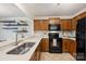 Bright kitchen with wooden cabinets, stainless steel sink, and floating shelves at 3302 Selwyn Farms Ln, Charlotte, NC 28209