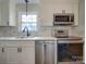 Modern kitchen with white cabinets, stainless steel appliances, and marble backsplash at 6815 Castlegate Dr, Charlotte, NC 28226