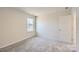 Well-lit bedroom with grey carpeting and window at 123 Dogwood Grove Pl, Troutman, NC 28166