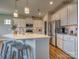 L-shaped kitchen island with seating, stainless steel appliances, and white cabinets at 123 Dogwood Grove Pl, Troutman, NC 28166