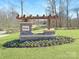 Inviting community entrance featuring a stone sign, pergola, and a beautifully landscaped flower bed at 1578 Croyden St, Indian Land, SC 29707