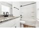 Renovated bathroom with granite vanity, white cabinets, matte black hardware, and a shower-tub combo at 624 W Kerr St, Salisbury, NC 28144