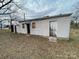 Backyard featuring an outbuilding with two doors and windows set on dry grass at 805 Railroad Ave, China Grove, NC 28023