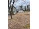 Backyard with an outbuilding set beyond a house in a yard covered with dry leaves at 805 Railroad Ave, China Grove, NC 28023