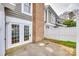 Backyard area with a set of French doors on a brick chimney in front of a white privacy fence at 8218 Legare Ct, Charlotte, NC 28210