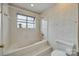 Bright bathroom featuring a tiled tub/shower combo with a window for natural light and floral patterned wallpaper at 8218 Legare Ct, Charlotte, NC 28210