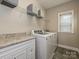 Bright laundry room with washer, dryer, and overhead shelving at 946 Emory Ln, Fort Mill, SC 29708