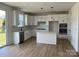 Bright kitchen with white cabinets, an island, stainless steel appliances, and hardwood floors at 1476 Hubert Graham Way, Tega Cay, SC 29708