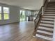 Spacious living room with hardwood floors, a staircase, and a view to the kitchen at 1476 Hubert Graham Way, Tega Cay, SC 29708