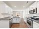 Open concept kitchen with white cabinets and hardwood floors at 221 Brenett Francis Ct, Charlotte, NC 28214