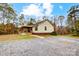 View of the house from the gravel driveway, showcasing the front porch and yard at 4450 Dobys Bridge Rd, Fort Mill, SC 29707