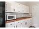 Kitchen featuring white cabinets, butcher block countertops, microwave and ample storage space at 161 Westscott Dr, Statesville, NC 28625