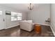 Bright living room with a modern chandelier, neutral walls, and dark hardwood flooring at 161 Westscott Dr, Statesville, NC 28625