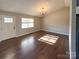 Bright living room with hardwood floors, a modern chandelier, and a window for natural light at 161 Westscott Dr, Statesville, NC 28625