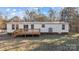 White mobile home with a wooden deck and large backyard at 2029 Big Dipper Dr, Clover, SC 29710