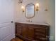 Traditional bathroom vanity with marble countertop, wood cabinetry, and stylish lighting fixtures at 317 Belwood Dr, Belmont, NC 28012