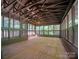 Large screened porch with wooden floor, exposed beam ceiling, railings, and views of the wooded yard at 317 Belwood Dr, Belmont, NC 28012