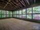 Inviting screened porch with exposed beam ceiling and wooden floor with multiple windows and railings at 317 Belwood Dr, Belmont, NC 28012