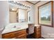 Bathroom vanity showcasing wood cabinets, decorative mirror, and a comfortable wicker chair at 4556 Harley Davidson Dr, Catawba, NC 28609