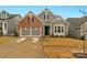 Gray and brick two-story house with a two-car garage and well-maintained lawn at 7014 Jolly Brook Dr, Charlotte, NC 28215