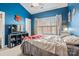 Vibrant bedroom with ceiling fan, large window with coverings, and a blue accent wall at 8931 Meadow Vista Rd, Charlotte, NC 28213