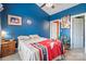 Cozy bedroom with bright blue walls, ceiling fan, and closet access at 8931 Meadow Vista Rd, Charlotte, NC 28213