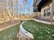 Backyard landscaping featuring a retaining wall, lawn, and bridge in a wooded area at 959 Tamary Way # 29/30, Landis, NC 28088