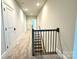 Upstairs hallway showcasing carpeted floors, white trim, and a staircase with a black railing at 959 Tamary Way # 29/30, Landis, NC 28088