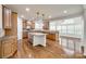 Bright kitchen features wood floors, light-brown cabinets, granite counters, and a center island with hanging pendant lights at 373 Fischer Rd, Fort Mill, SC 29715