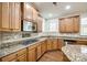 Bright kitchen features wood floors, light-brown cabinets, granite counters, backsplash and stainless steel appliances at 373 Fischer Rd, Fort Mill, SC 29715