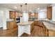 Bright kitchen features wood floors, light-brown cabinets, granite counters, and a center island with hanging pendant lights at 373 Fischer Rd, Fort Mill, SC 29715