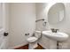 Clean powder room with pedestal sink, round mirror, and modern fixtures at 373 Fischer Rd, Fort Mill, SC 29715