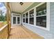 View of the spacious covered porch with wood decking and railing, and view of side yard at 562 Shepherd Ln # 3, Clover, SC 29710