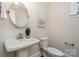 Stylish powder room with a pedestal sink, round mirror, and modern light fixture at 562 Shepherd Ln # 3, Clover, SC 29710