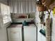 White washer and dryer in a small laundry room with shelves and window at 614 Morven Rd, Wadesboro, NC 28170