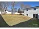 Sloped backyard with a partial view of the house and surrounding trees at 816 Wellwood Ave, Statesville, NC 28677