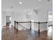 Upstairs hallway with dark wood floors and wrought iron railing at 3907 E Lawyers Rd, Monroe, NC 28110