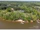 Aerial view of estate home on lakefront property surrounded by mature trees, ensuring privacy at 1140 Inlet Pointe Rd, Salisbury, NC 28146