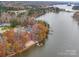 Lake house nestled among trees featuring a private dock, beach, and waterfront views at 1140 Inlet Pointe Rd, Salisbury, NC 28146