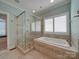 Elegant bathroom with a glass shower and a separate tub with white shutters at 1140 Inlet Pointe Rd, Salisbury, NC 28146