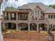 A two-story brick house featuring outdoor seating and entertaining space, stone patios, and a fenced backyard at 1140 Inlet Pointe Rd, Salisbury, NC 28146