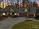 Stately home with a circular driveway, three-car garage, and well-manicured landscaping at dusk at 1140 Inlet Pointe Rd, Salisbury, NC 28146